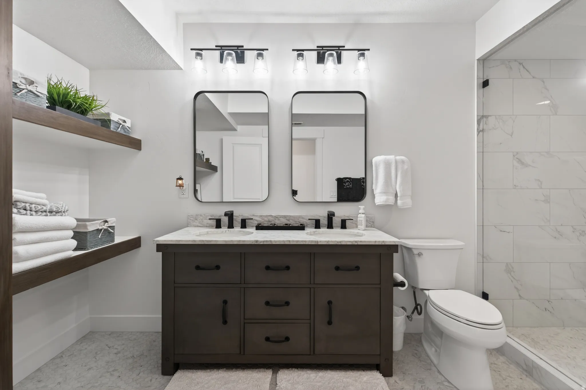Full bathroom with double vanity and tiled shower
