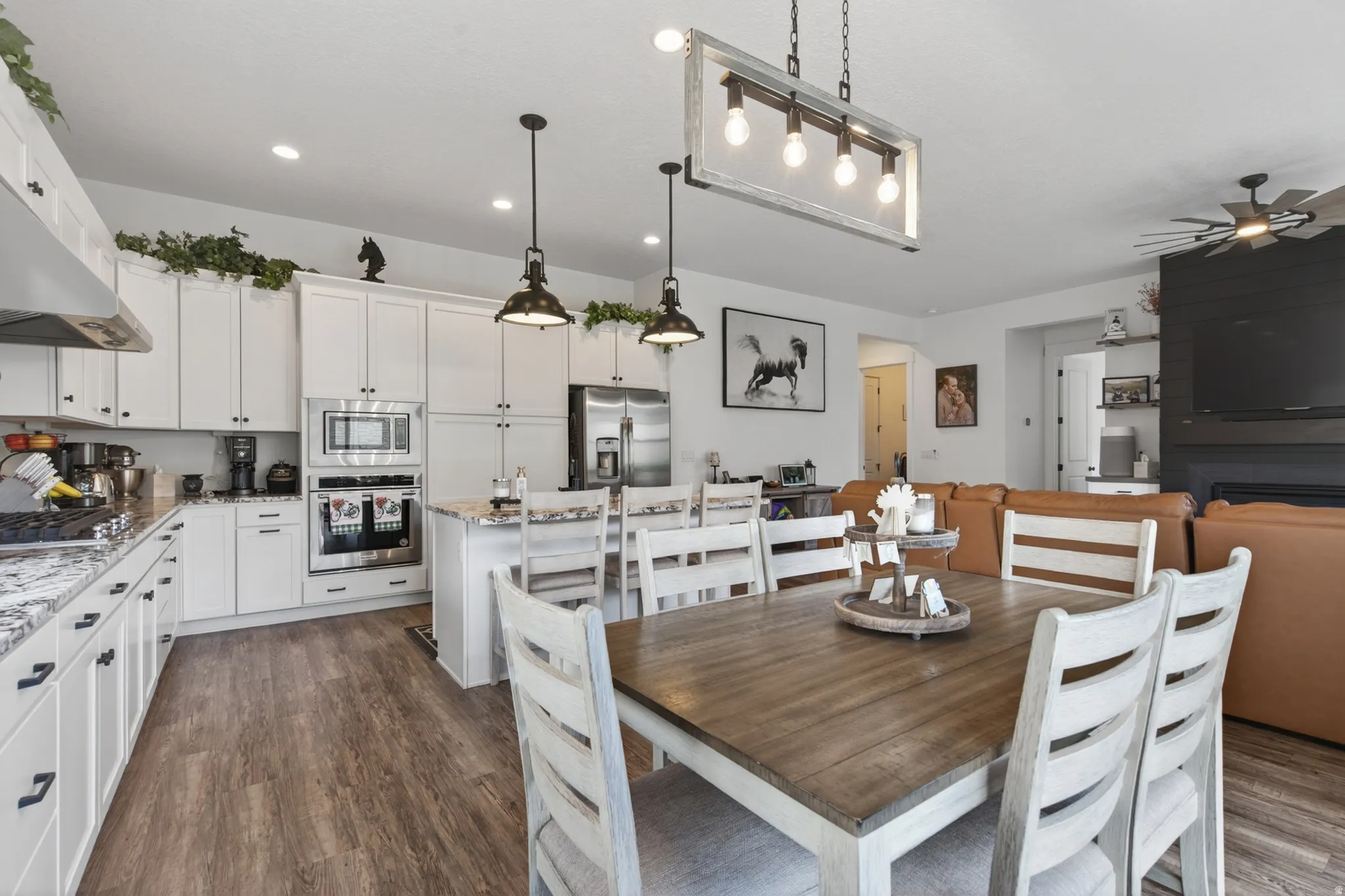 Dining area with dark wood-style floors and ceiling fan