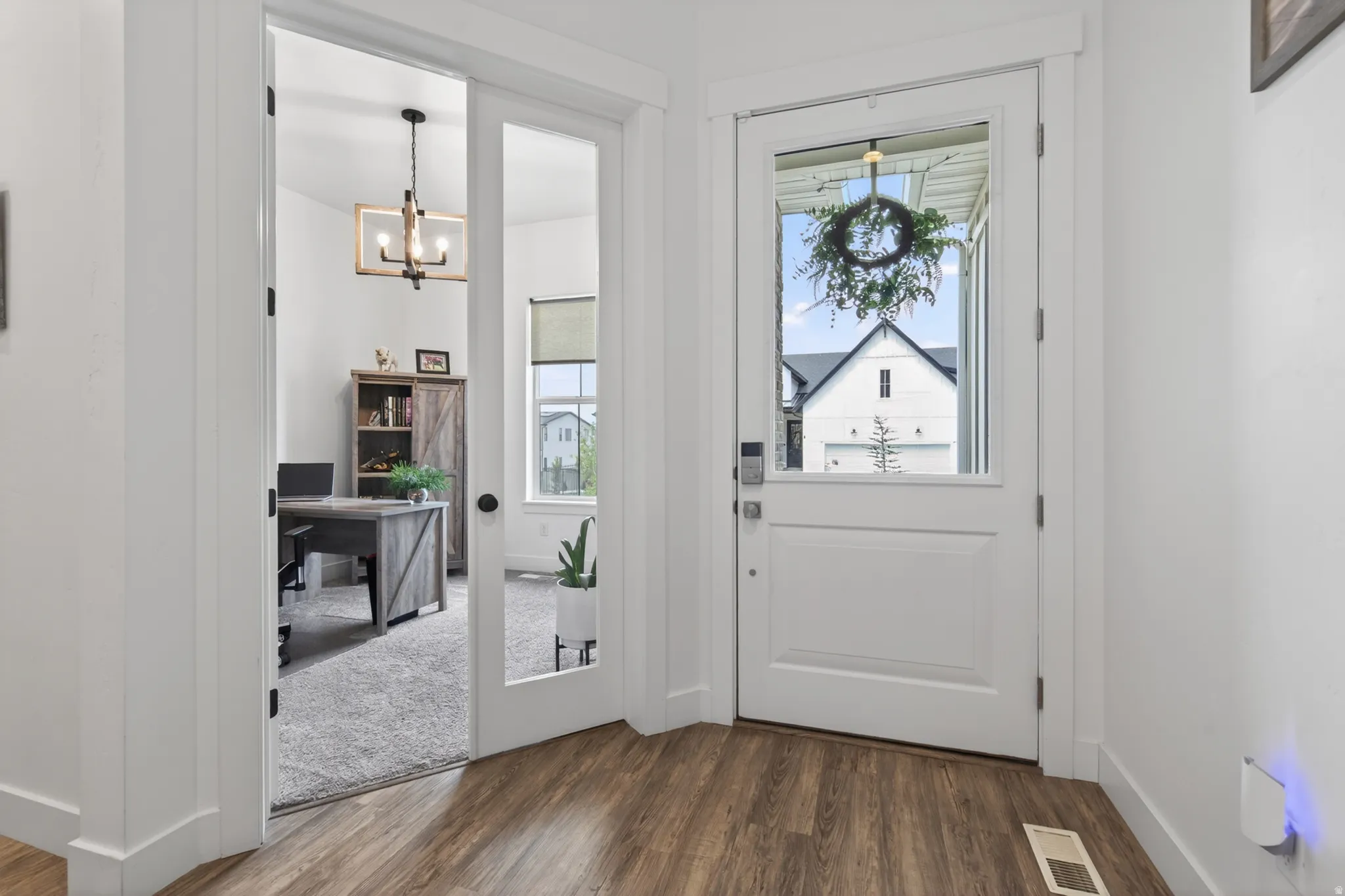 Entryway with a chandelier and dark wood-style floors