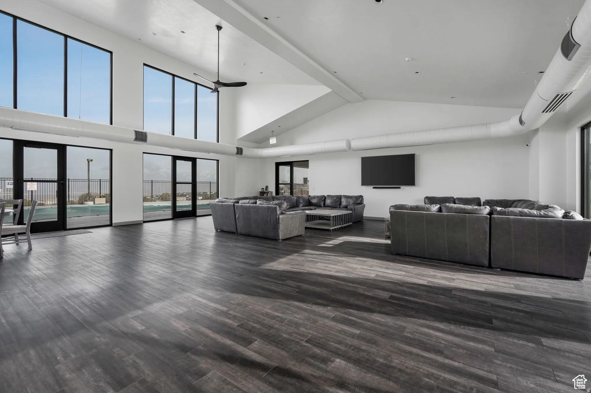 Living room featuring dark wood finished floors, vaulted ceiling, and a ceiling fan