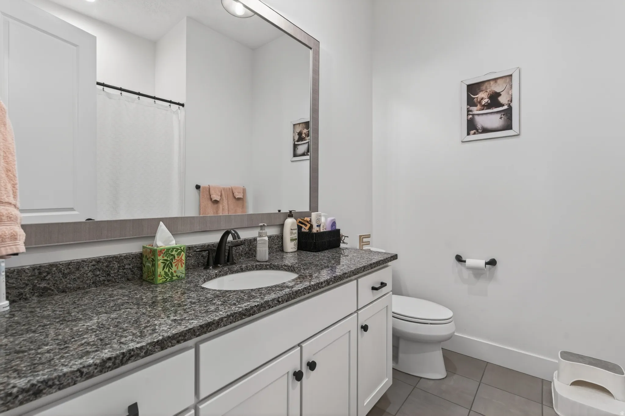 Bathroom featuring vanity, a shower with shower curtain, and light tile patterned flooring