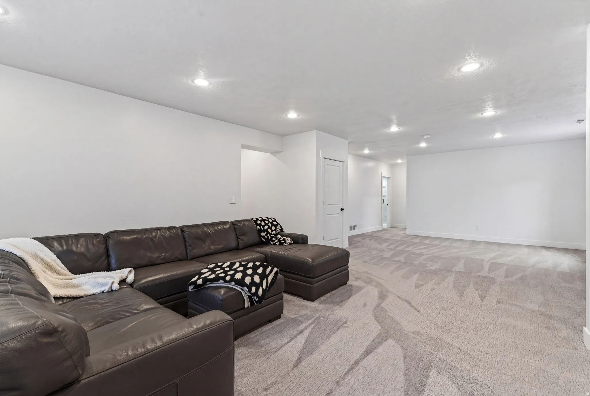 Living room with recessed lighting and light colored carpet