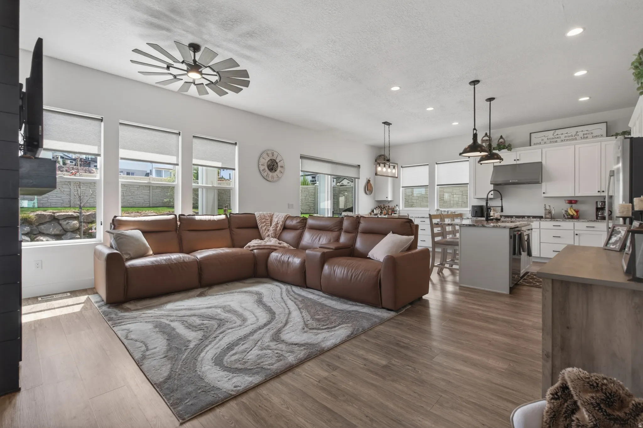 Living area with dark wood-style floors, recessed lighting, a textured ceiling, and a ceiling fan