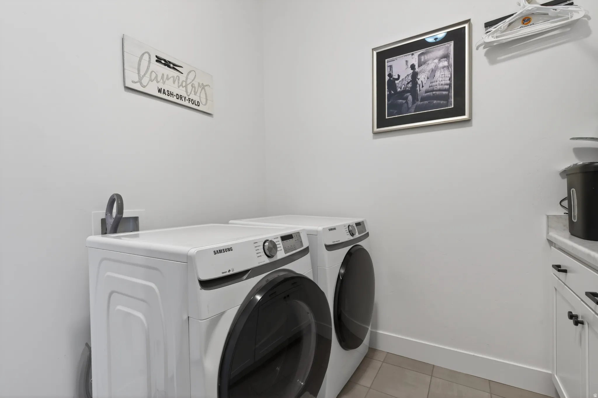 Laundry area featuring light tile patterned flooring and washer and dryer