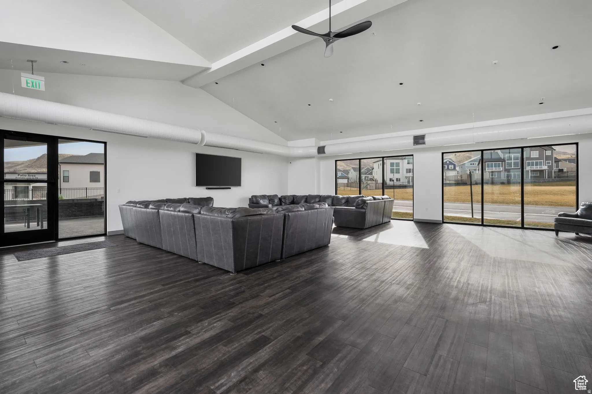 Living area with ceiling fan and dark wood-style floors