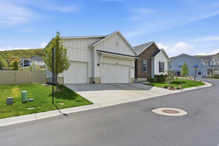 Contemporary residence featuring white board-and-batten siding and a dual garage