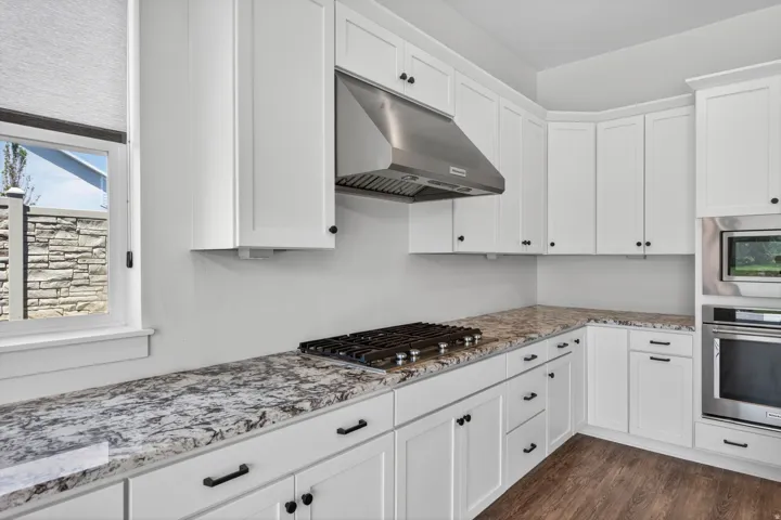 Modern kitchen featuring white shaker cabinetry with dark hardware