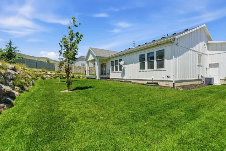 Spacious rear yard with a verdant lawn and mature landscaping