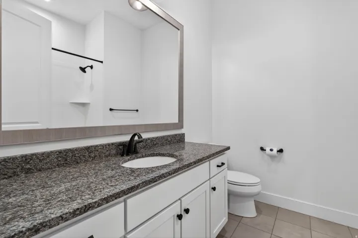 Bathroom featuring a vanity with a granite countertop, undermount sink, and matte black faucet