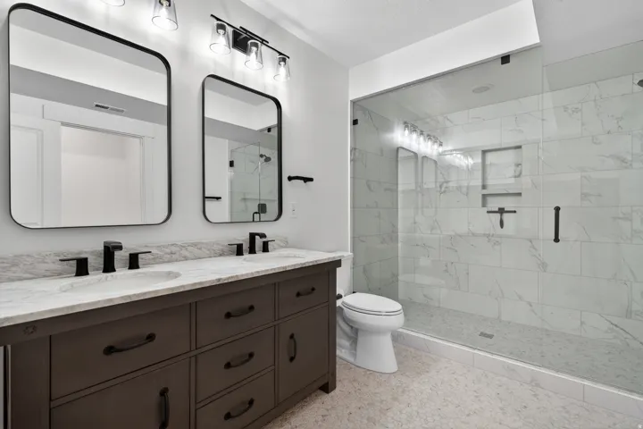 Dual basin vanity with matte black hardware and a solid surface countertop