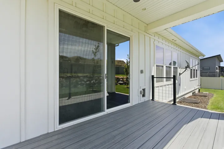 Exterior deck featuring composite decking and a white board and batten siding