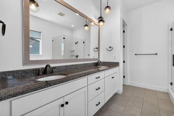 Double vanity with granite countertops, undermount sinks, and matte black fixtures