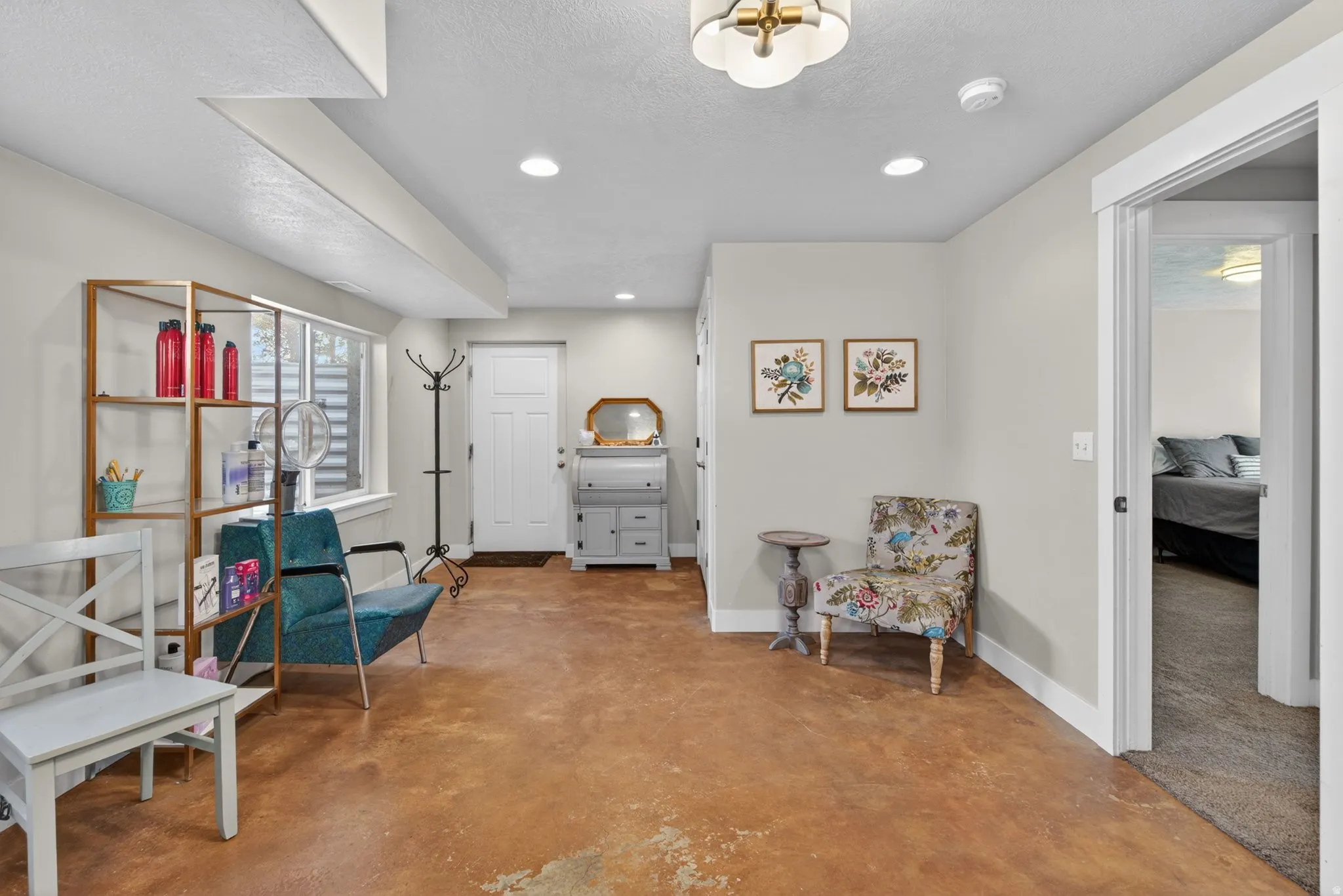 Living area featuring recessed lighting, finished concrete floors, and a textured ceiling