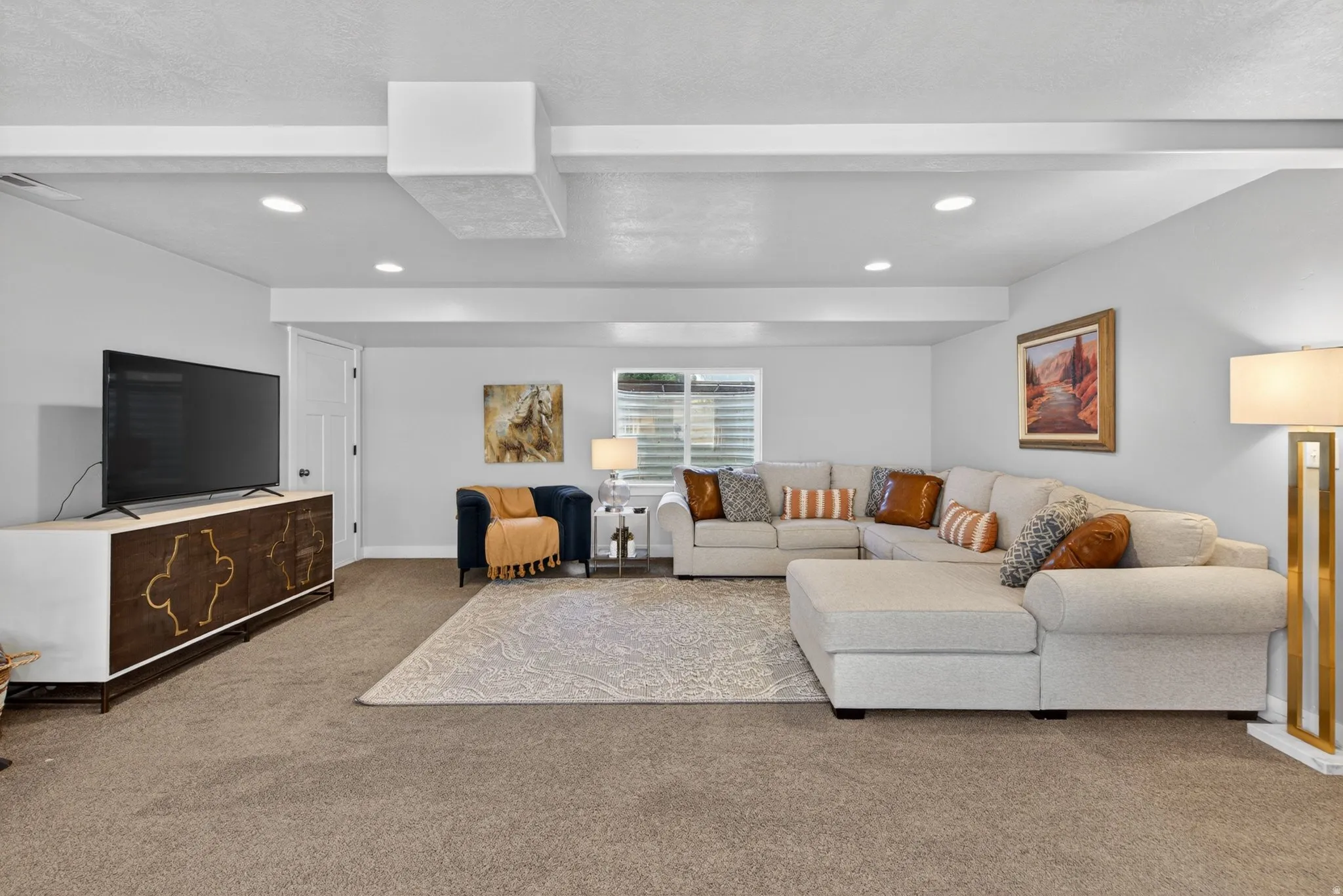 Carpeted living area with a textured ceiling and recessed lighting