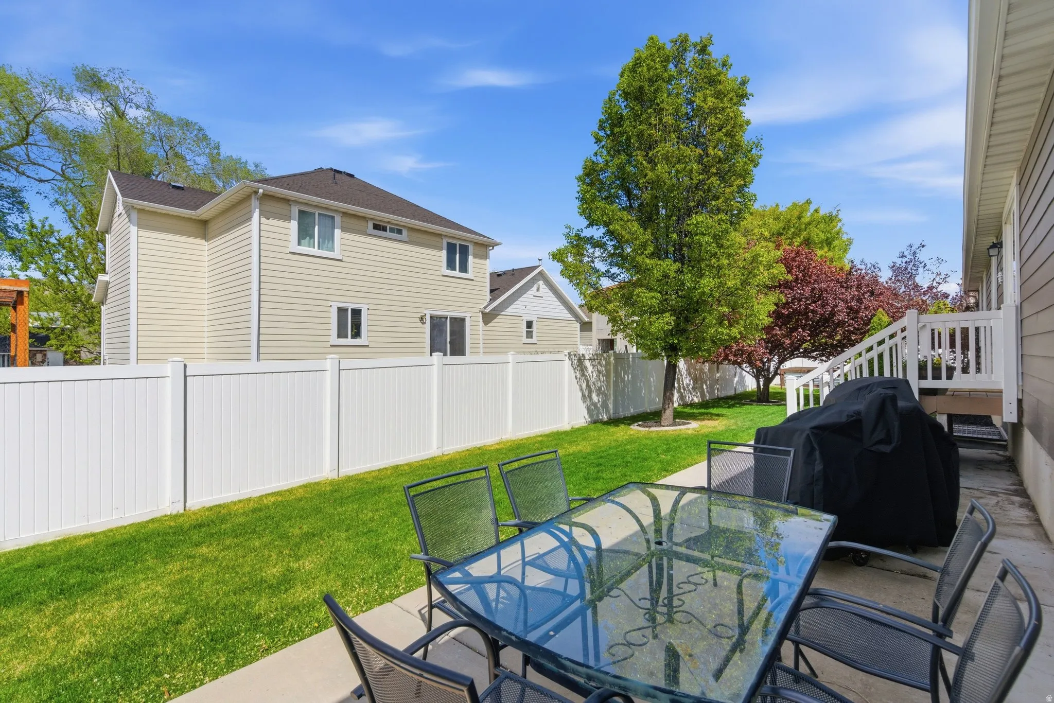 Fenced backyard featuring a patio area, a grill, and outdoor dining space
