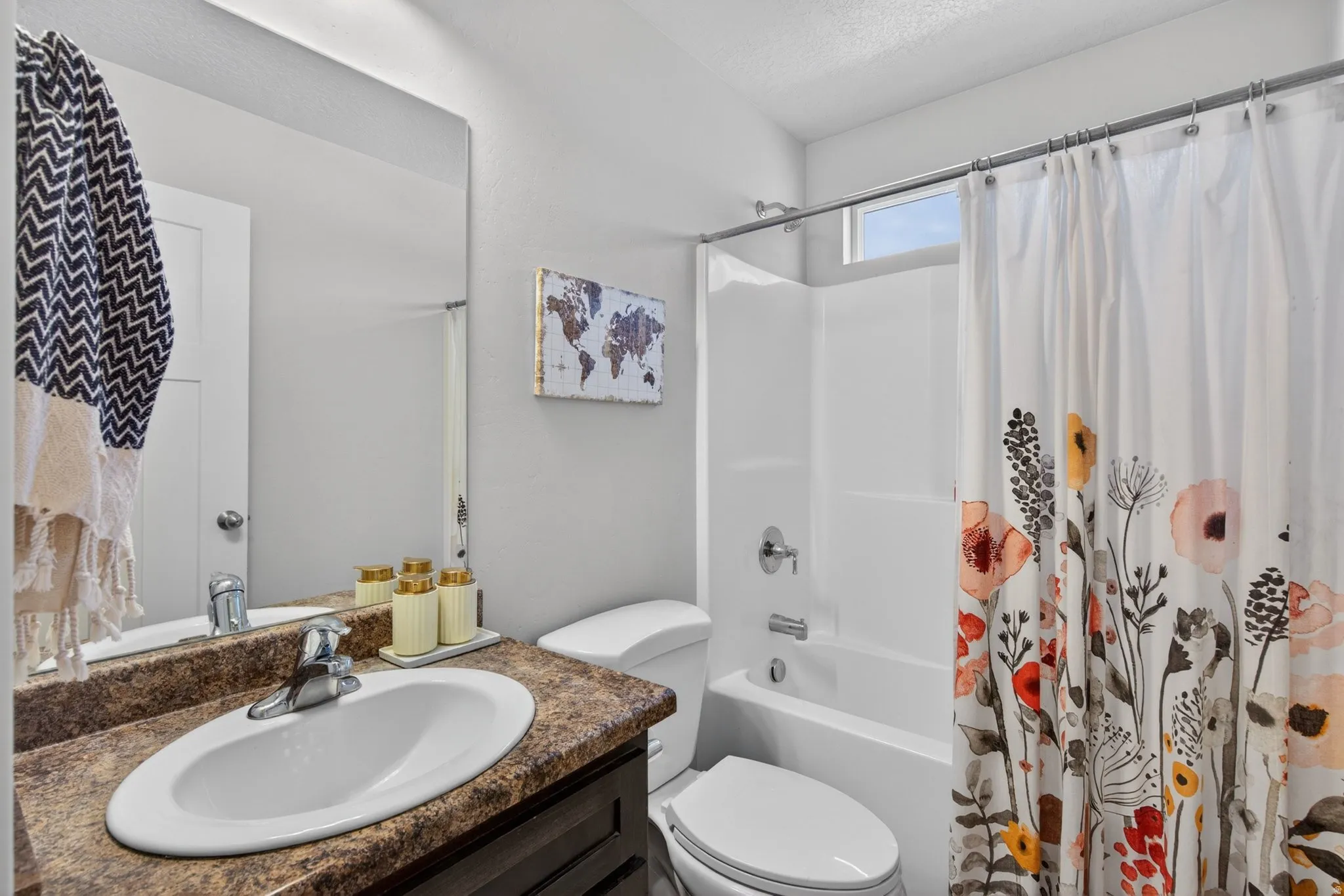 Bathroom with vanity, shower / bath combo, and a textured ceiling