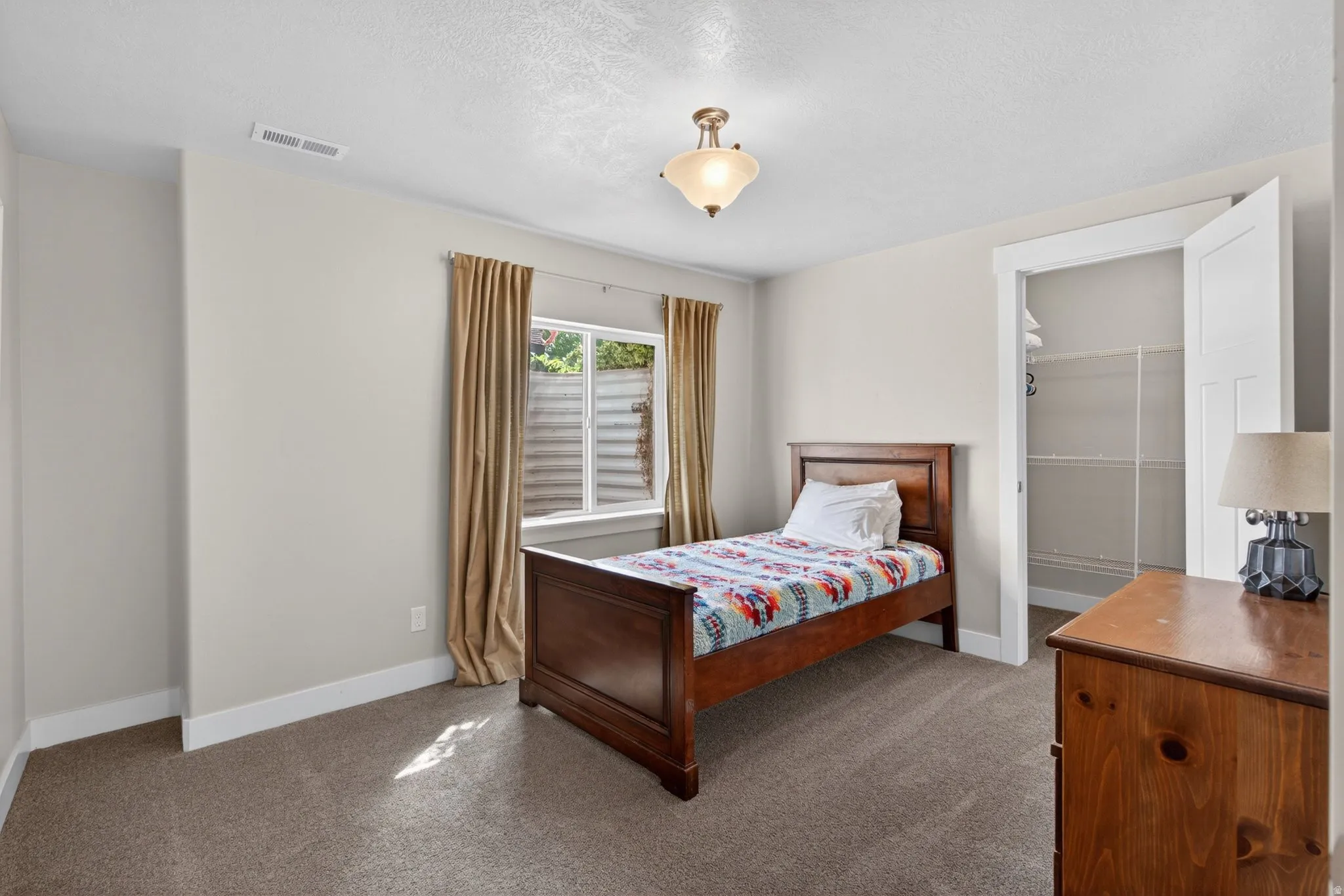 Bedroom featuring dark colored carpet and a textured ceiling