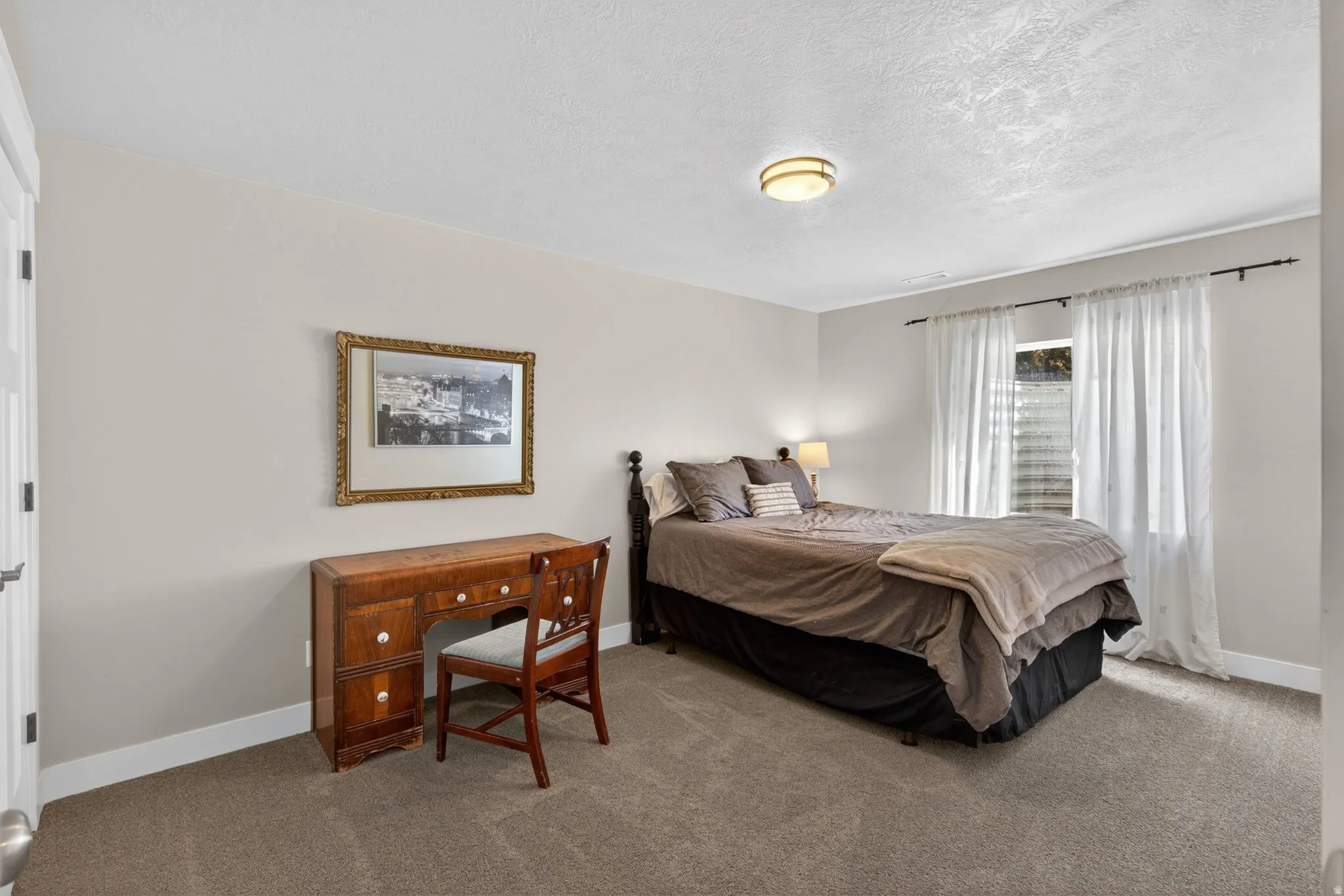 Bedroom featuring carpet and a textured ceiling