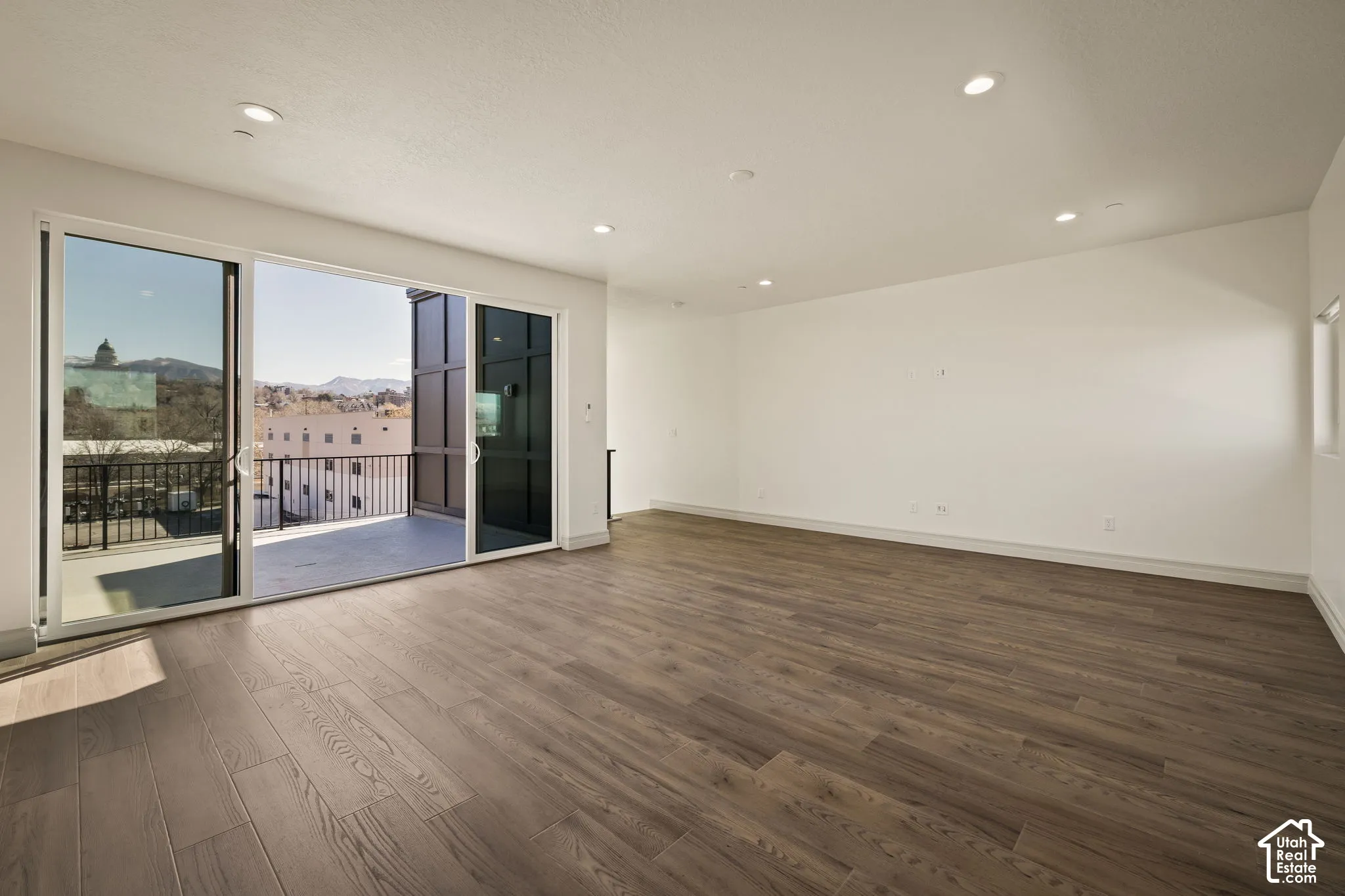 Unfurnished room with dark wood finished floors, a mountain view, and recessed lighting