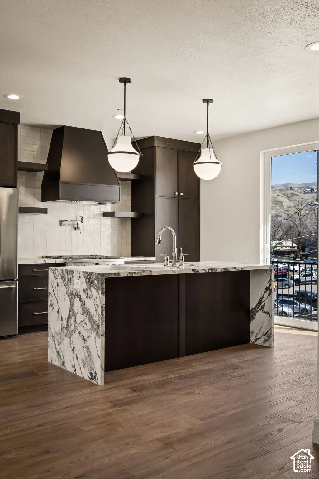 Kitchen featuring dark wood finish cabinetry, light stone countertops, and dark wood finished floors