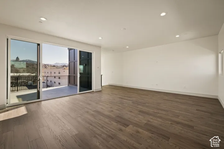 Unfurnished room with dark wood finished floors, a mountain view, and recessed lighting