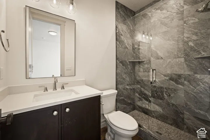 Full bathroom with vanity and a marble finish shower