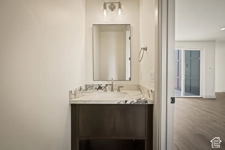 Half bath with vanity and wood finished floors