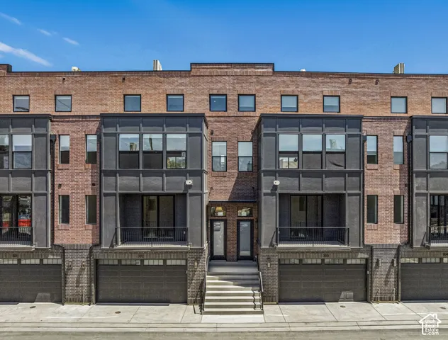 Contemporary townhome exterior featuring a brick facade with dark gray architectural accents