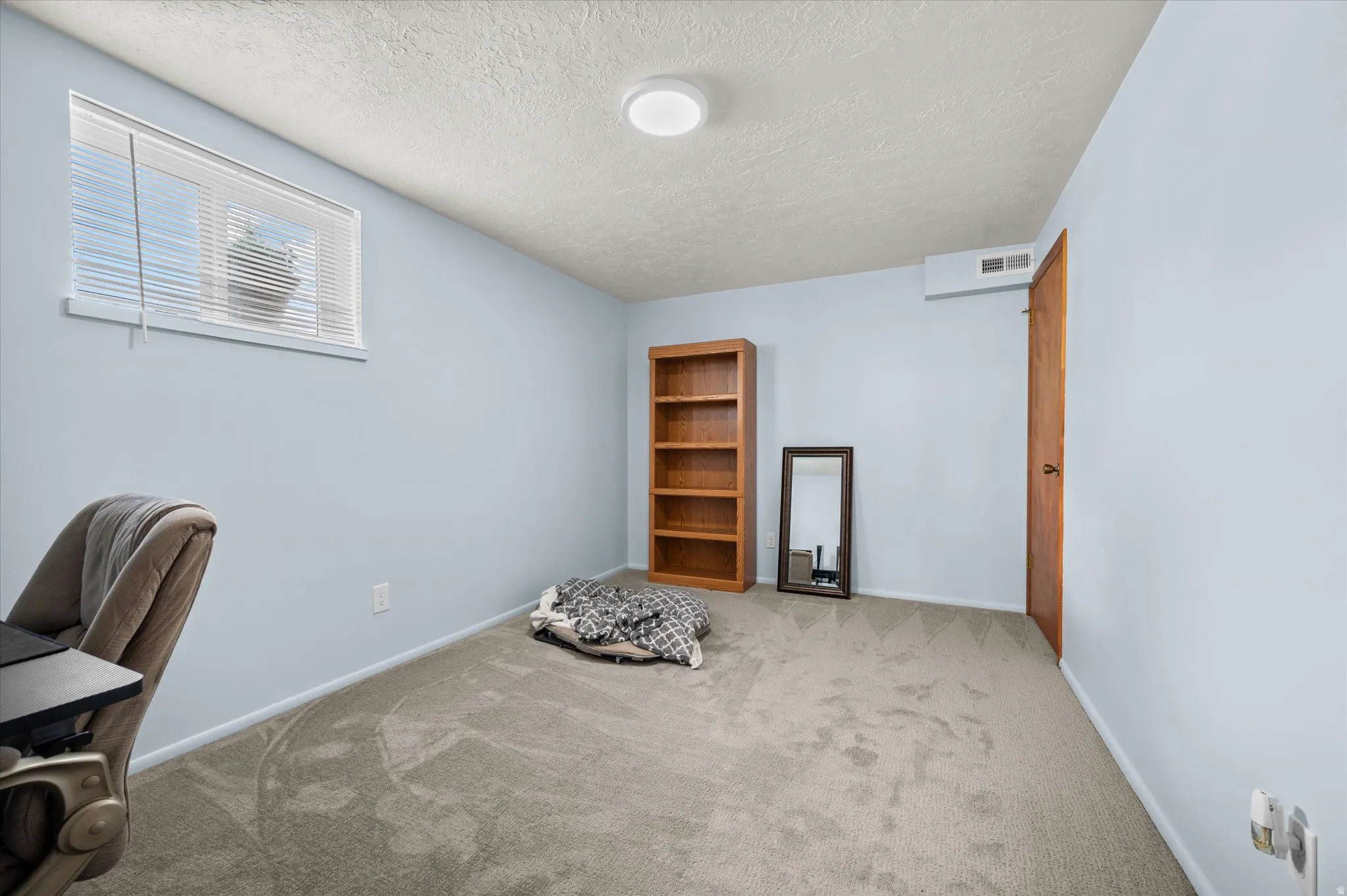 Unfurnished office with light carpet and a textured ceiling