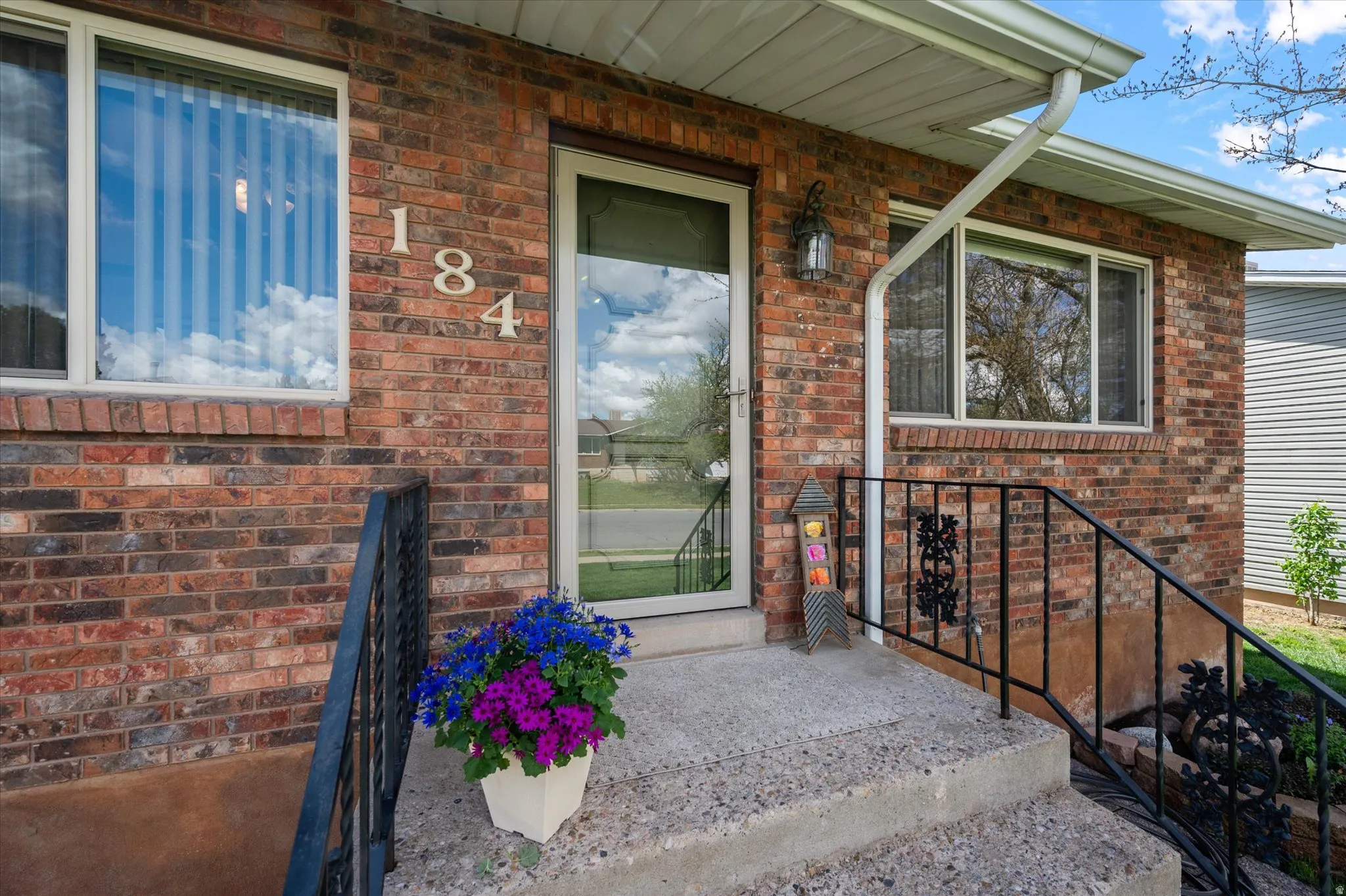 Doorway to property featuring brick siding and a porch