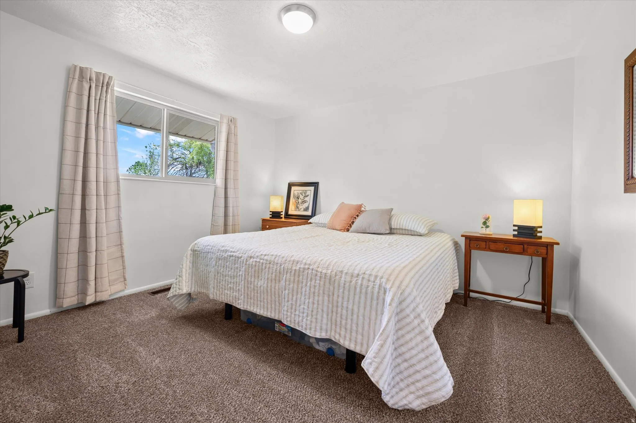 Bedroom featuring dark carpet and a textured ceiling