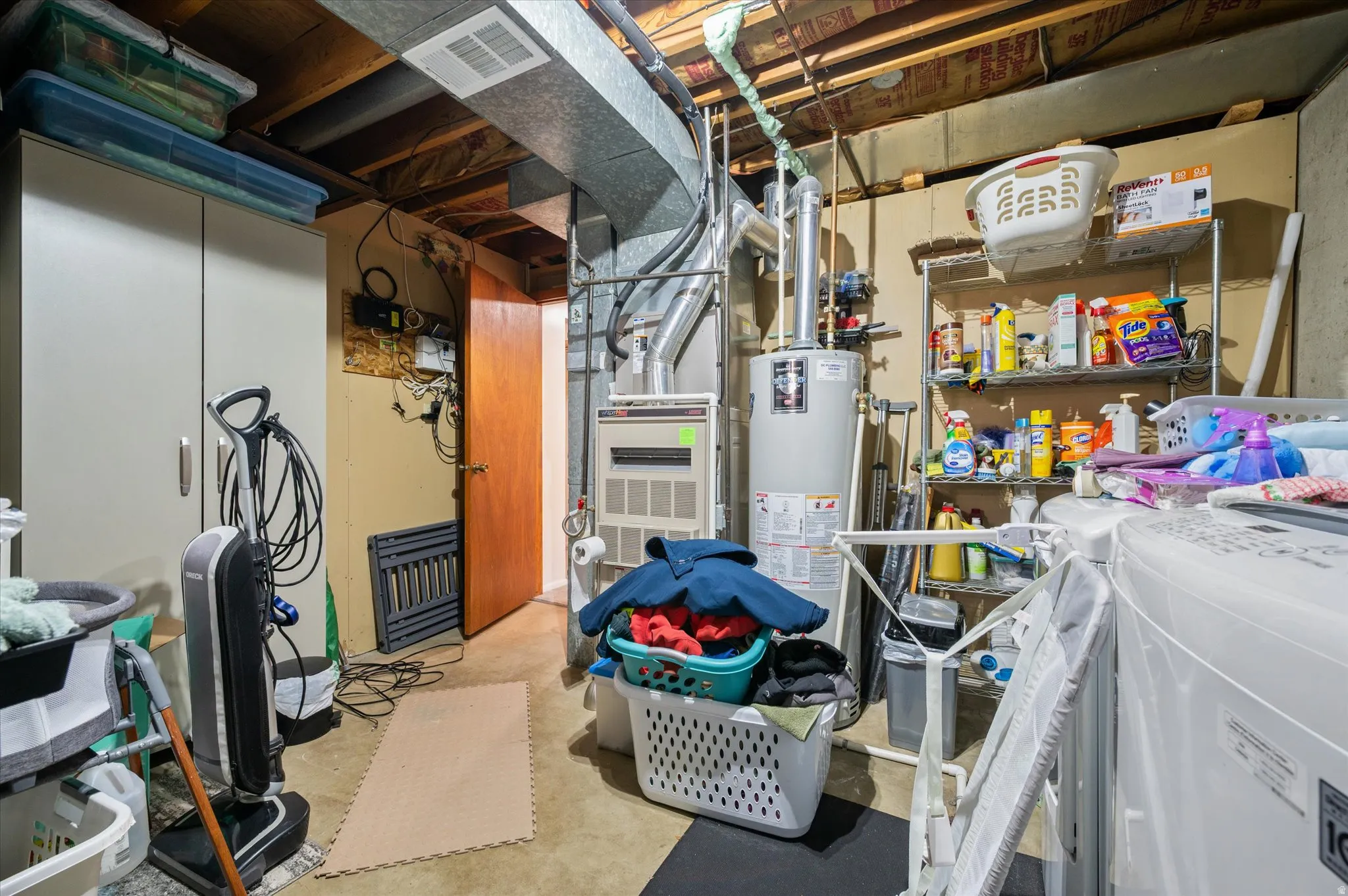Unfinished below grade area featuring water heater, heating unit, and independent washer and dryer
