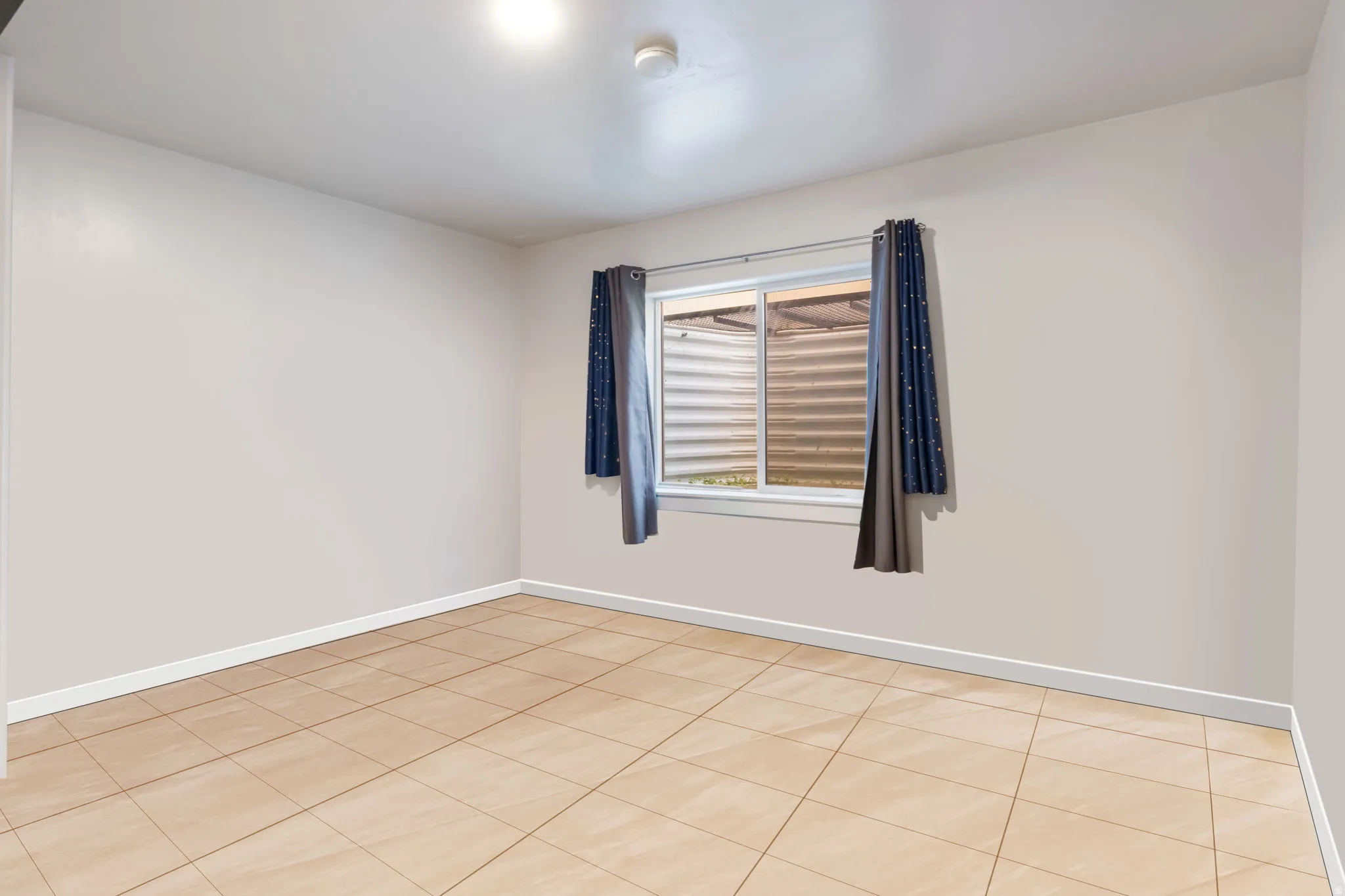 Spare room featuring baseboards and light tile patterned floors