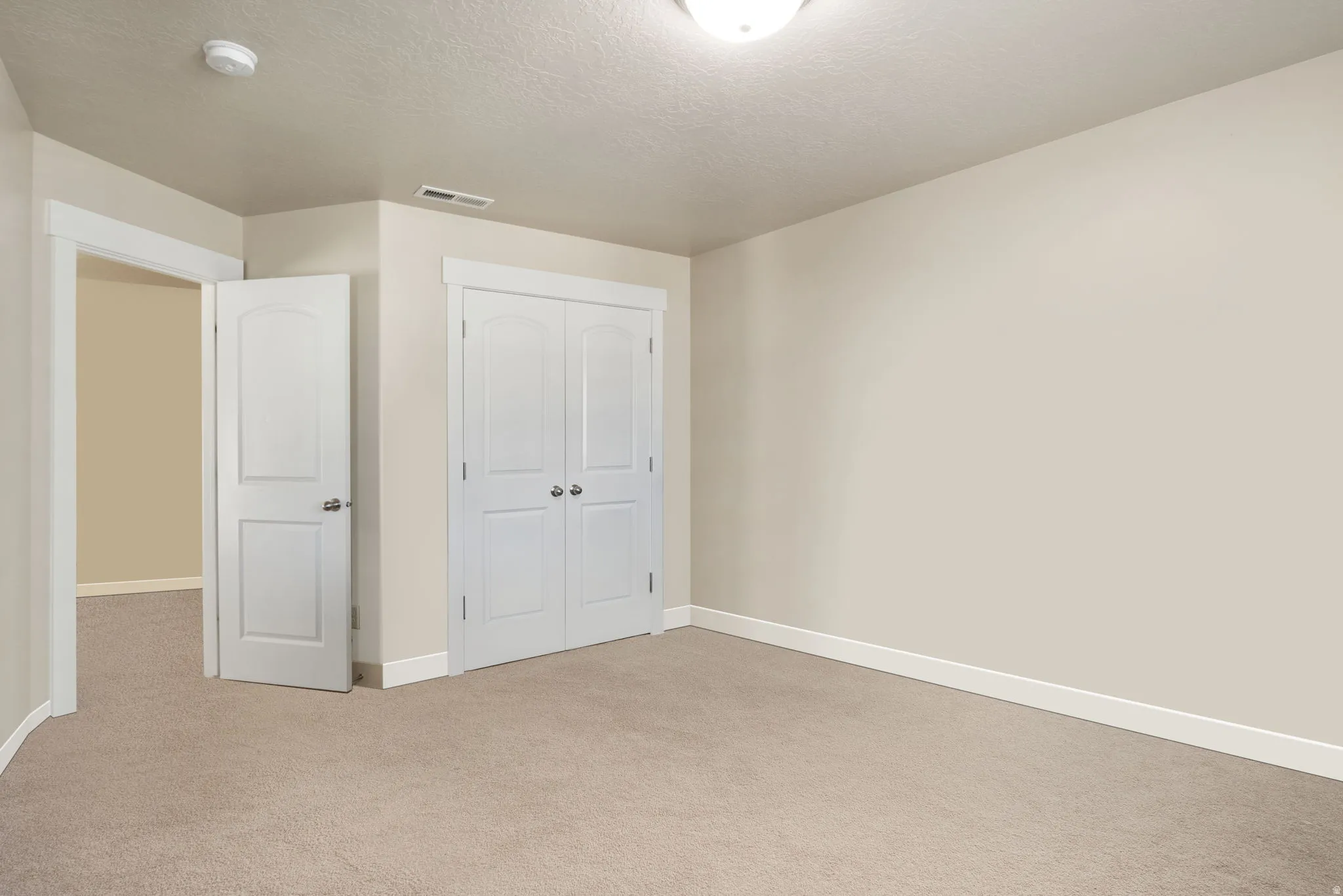 Unfurnished bedroom with carpet, a closet, and a textured ceiling
