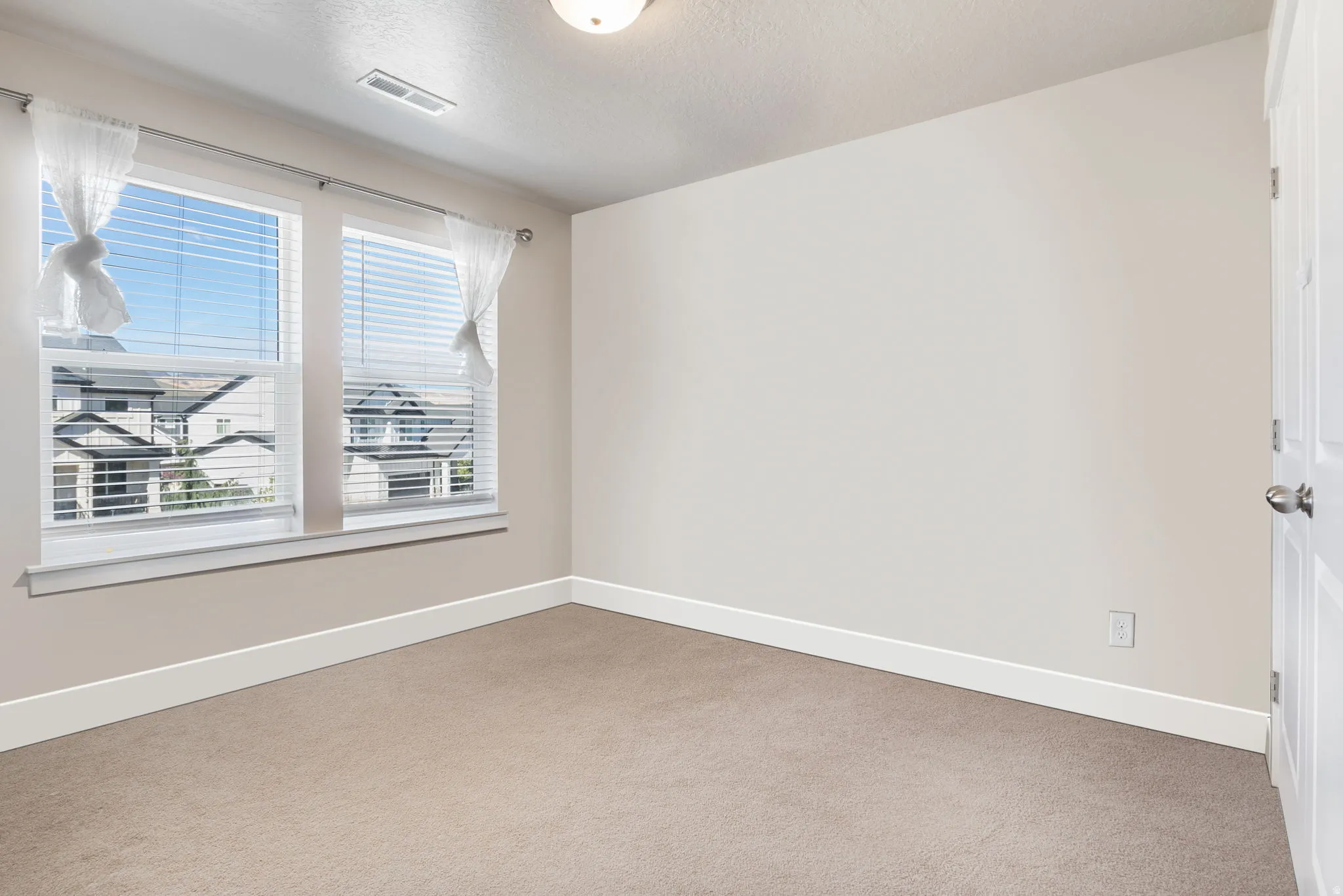 Unfurnished room with carpet flooring and a textured ceiling
