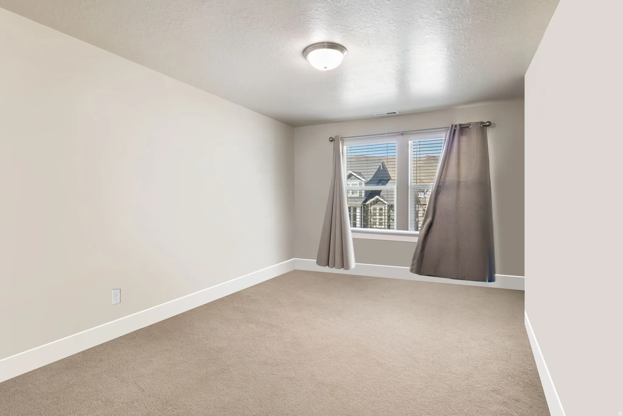 Carpeted spare room featuring a textured ceiling