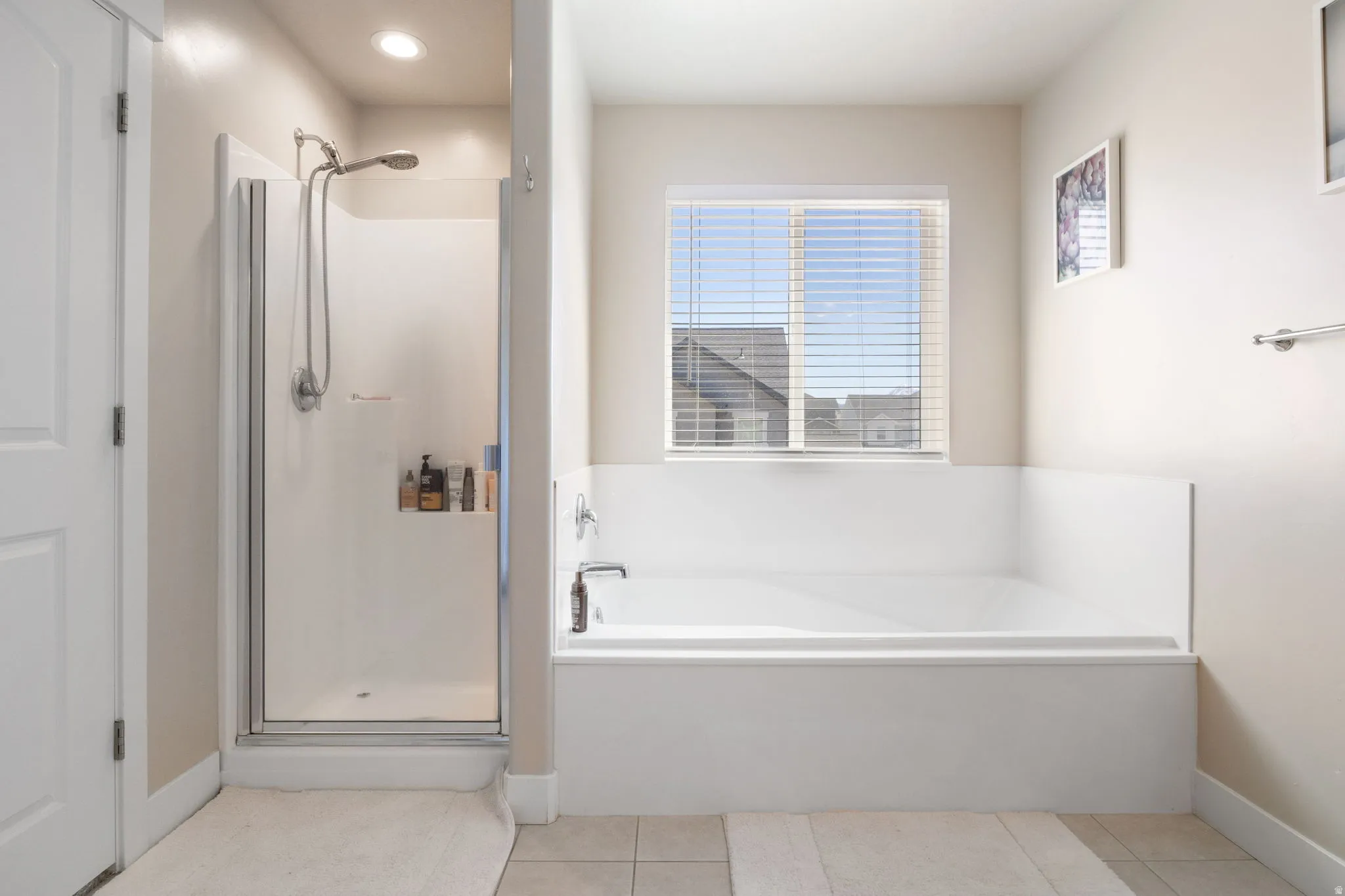 Bathroom featuring a shower stall, a bath, and light tile patterned floors