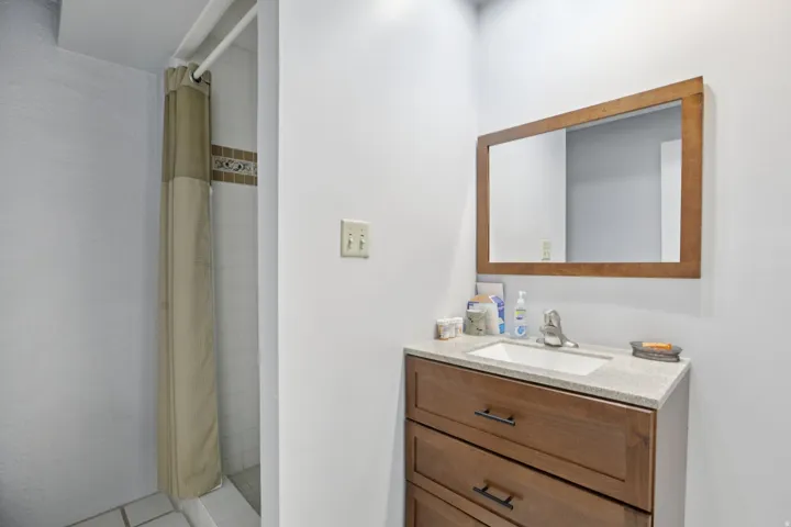 Full bathroom featuring a stall shower, vanity, and light tile patterned floors