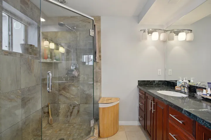 Bathroom with vanity, a shower stall, and light tile patterned floors