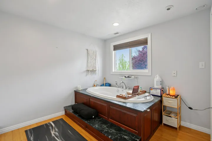Bathroom featuring a bath and light wood-style flooring