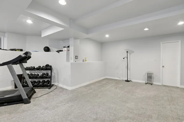 Workout room featuring carpet flooring, recessed lighting, and radiator