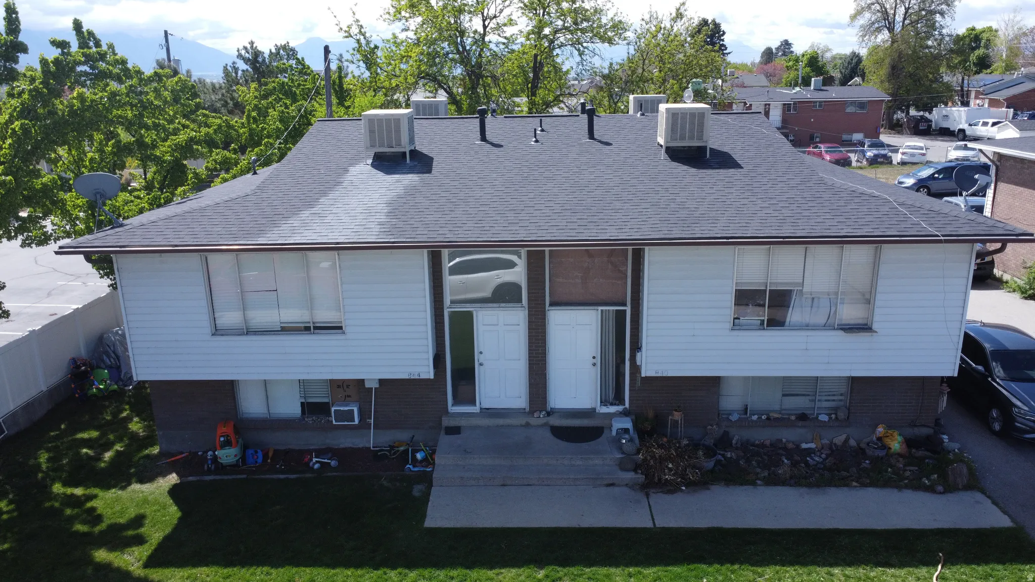 Rear view of house with roof with shingles and brick siding