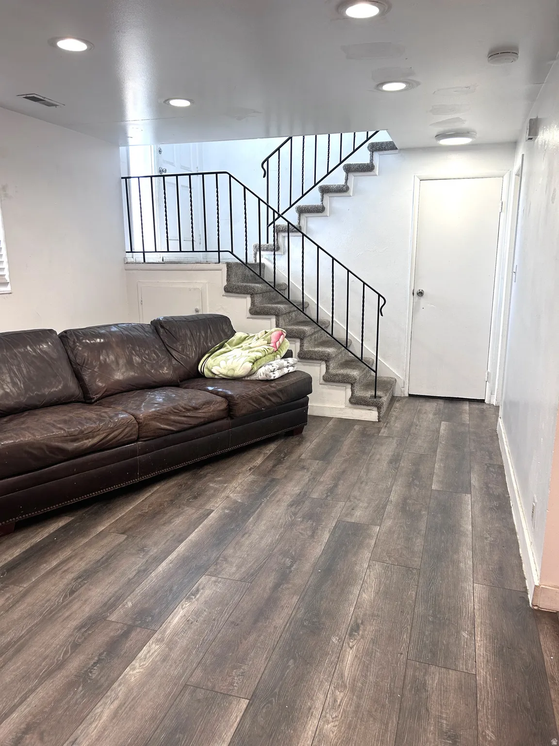 Living area with wood-type flooring and recessed lighting