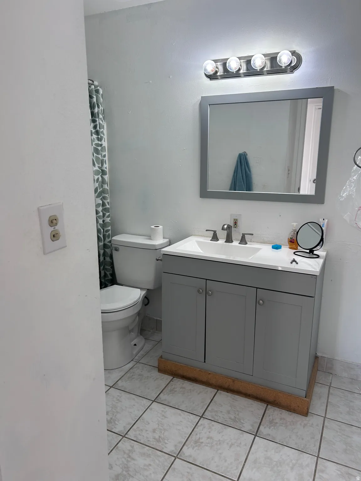 Full bath featuring vanity, light tile patterned floors, and a shower with shower curtain