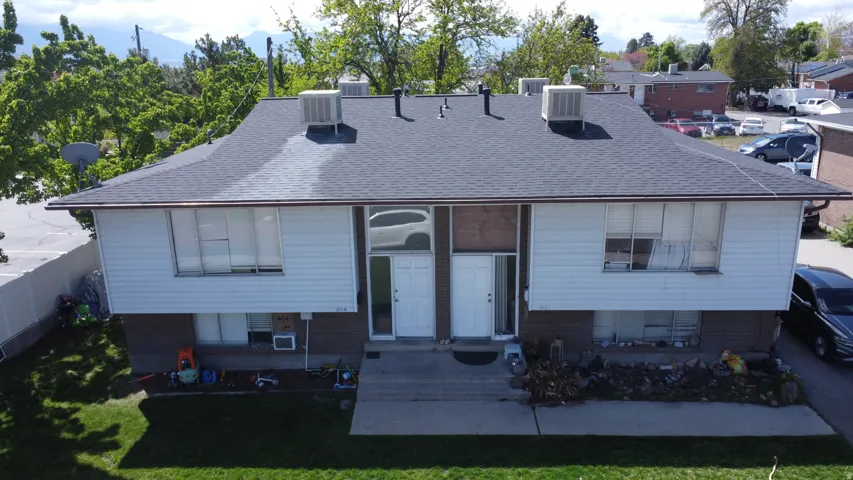 Rear view of house with roof with shingles and brick siding