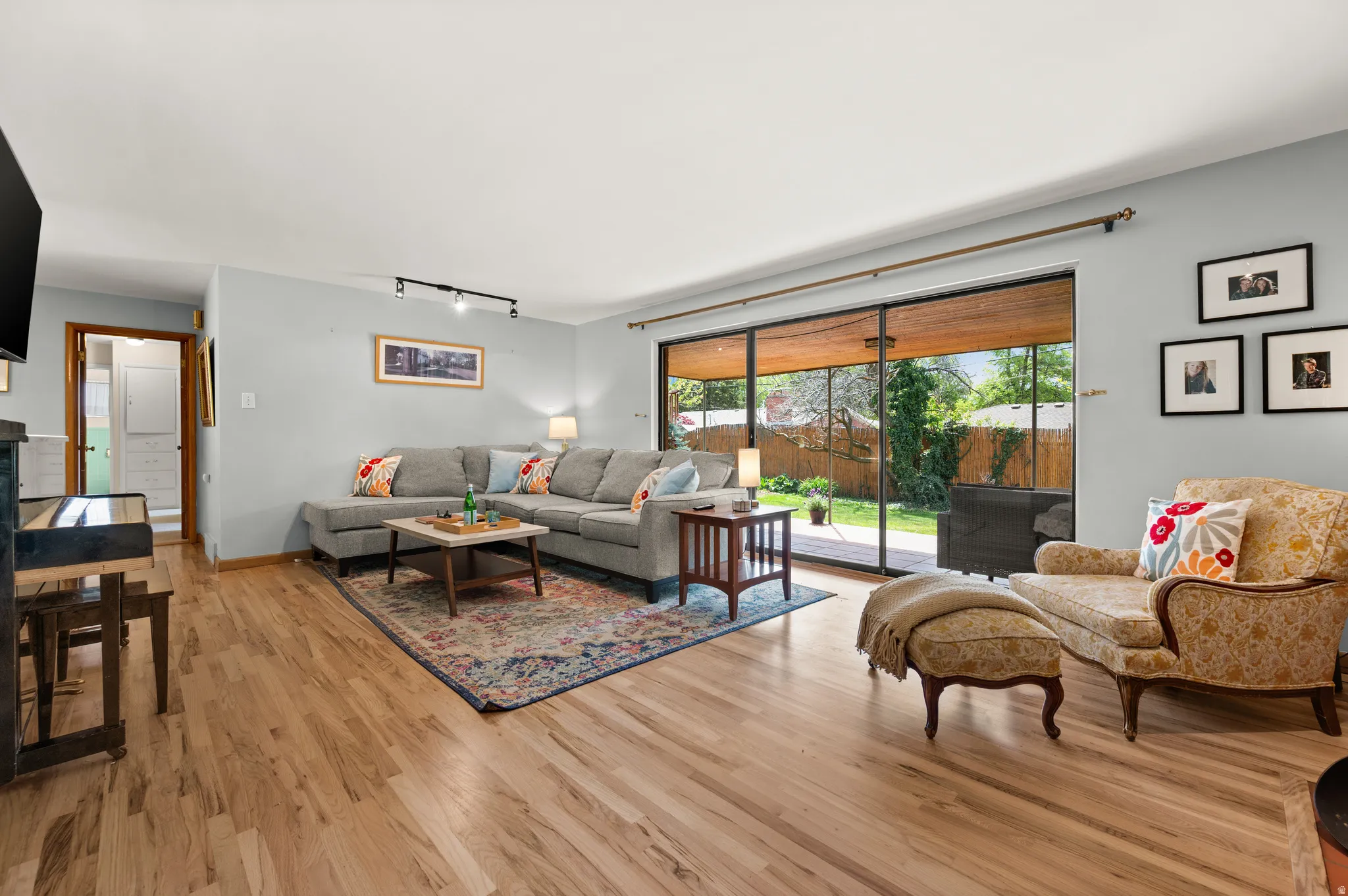 Spacious lifing room with big windows and sliding door out to the back patio