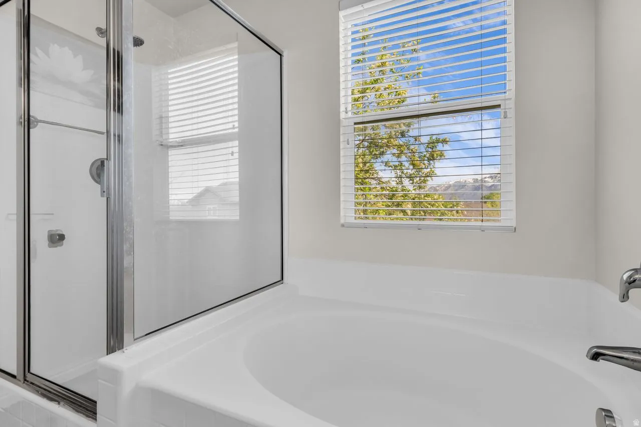 Primary bathroom with a bath and a stall shower
