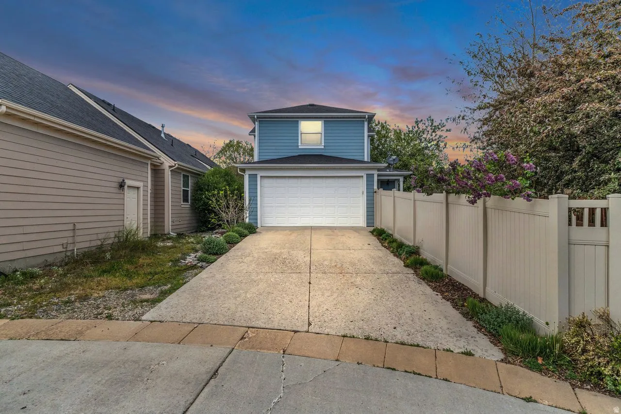 View of back of home with driveway and an attached garage