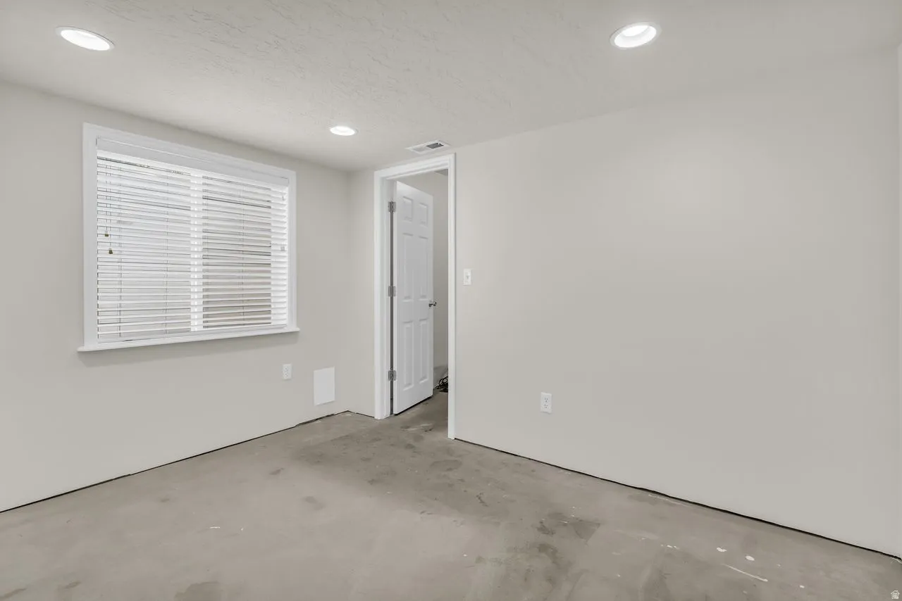 Basement bedroom with recessed lighting and concrete flooring