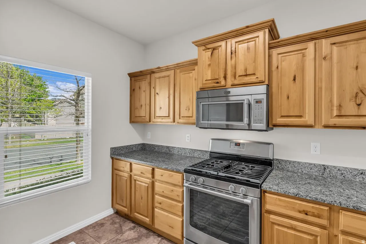 Kitchen with stainless steel appliances and dark granite counters